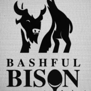 Black and white logo for "Bashful Bison" featuring a stylized illustration of a bison with its head turned shyly and another bison facing away; the letter “O” in “BISON” is creatively designed as a spoon, suggesting a culinary theme.