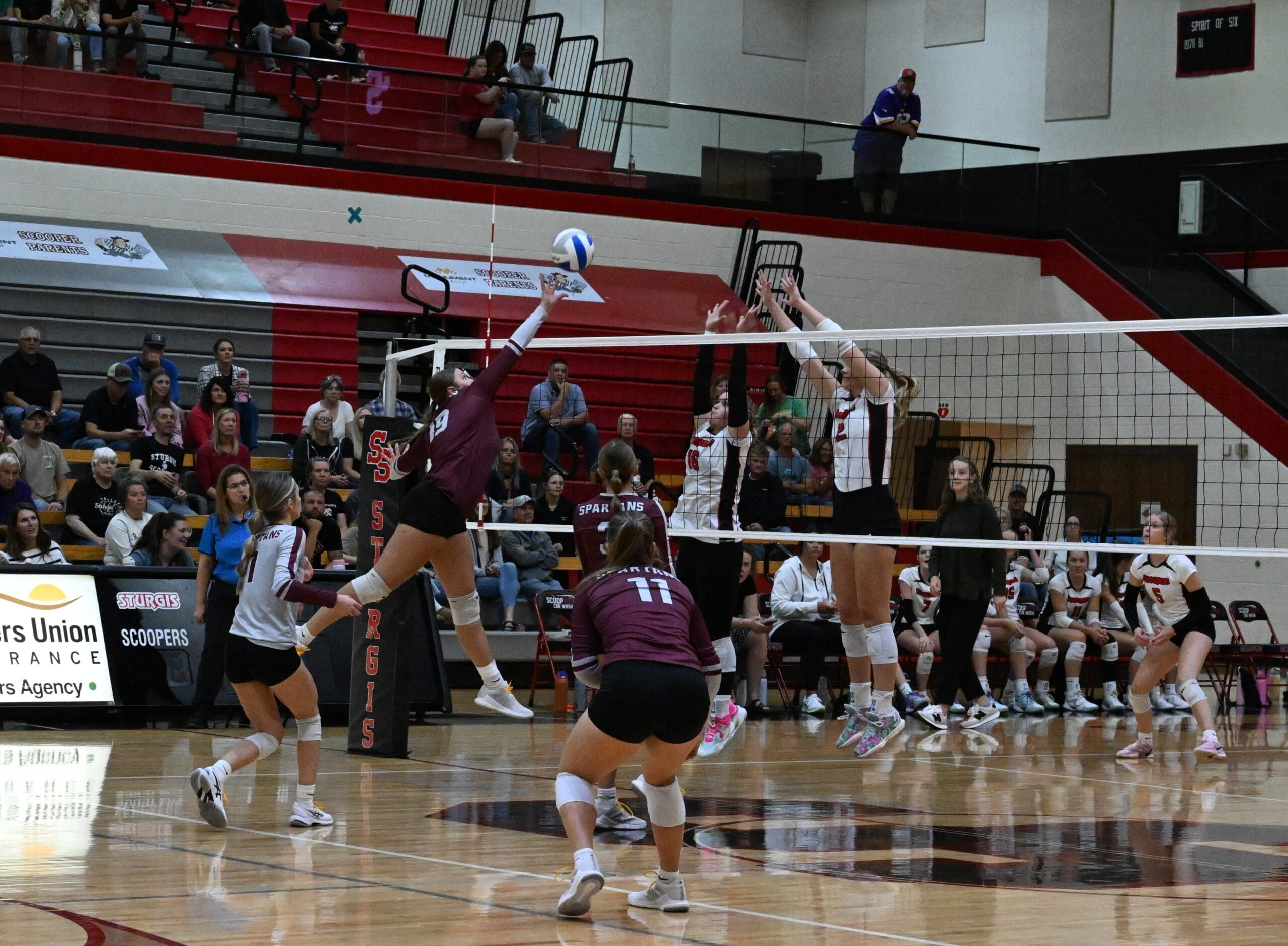 Spearfish Spartans volleyball player Addison Keller jumps for a kill against two Sturgis Scoopers blockers during a varsity match on September 23, 2025.