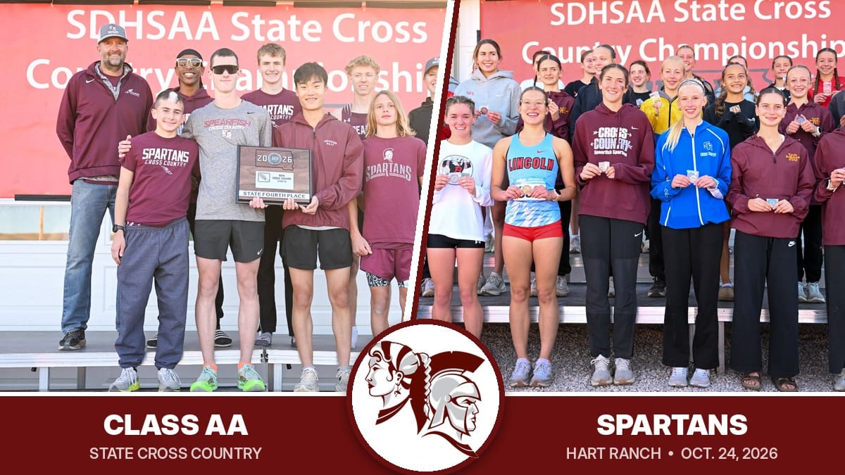 Spearfish Spartans boys cross country team holding the Class AA state fourth-place plaque next to state medalists, including a Spearfish runner, at the 2026 SDHSAA State Cross Country Championships at Hart Ranch.
